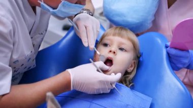 Diş cerrahisindeki genç kız. Klinikteki kıza diş tedavisi uygulayan bir dişçi.