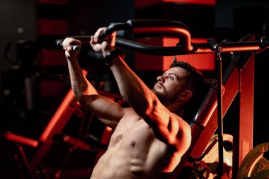 Athletic handsome man with muscular body working out. Strong fitness model with naked torso.