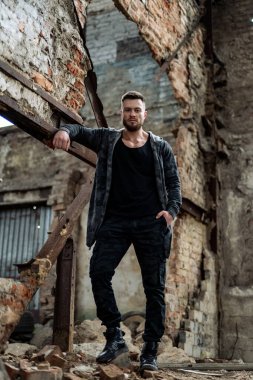Serious young guy in abandoned building. Handsome man in casual cloth on ruined building.