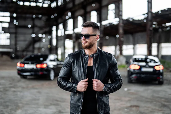Brutal successful man in leather jacket. Stylish man in biker black jacket and sunglasses.
