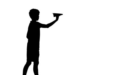 Small boy holds a paper plane in hand isolated on white studio background. Silhouette of a boy with origami plane 