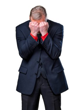 Portrait of a sad man standing on white background. Senior man covers face with hands. Depression of a businessman in suit.