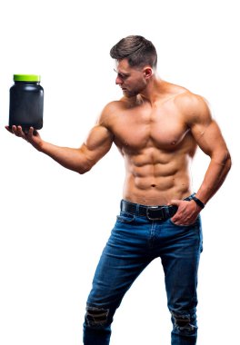 Male athlete bodybuilder with a naked torso stands with a jar of sports nutritional supplements. Isolated on white studio background