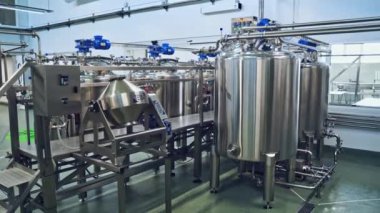 Süt ürünleri fabrikasındaki ekipman. Paslanmaz çelik bacak destek tanklarıyla modern süt mahzeni