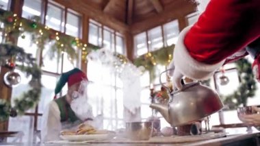Noel Baba 'nın etrafında elfler. Noel Baba ve elfler Noel ziyafeti çekiyor.