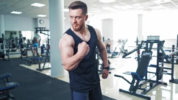 Atletische Man Model Poseren Sportschool Bodybuilder Demonstreert Zijn Armkracht Sportschool — Stockvideo