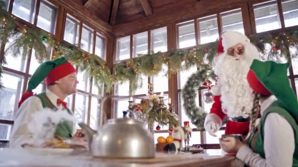 Weihnachtsmann Und Frau Zimmer Weihnachtsmann Mit Elfen Beim Essen Dekoriertem — Stockvideo
