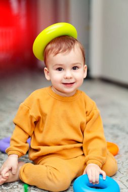 Funny playful kid with toys. Curious smilling baby with colorful educational toy.