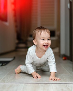 Playful little child on the floor. Joyful happy son having fun on the floor.