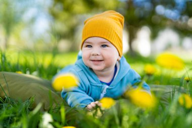 Çiçek tarlasında küçük bir çocuk. Sarı çiçeklerin arka planına yakın plan portresi. 