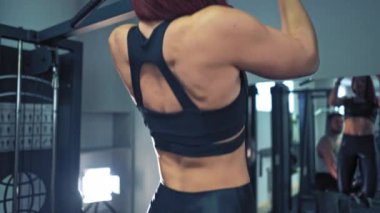 Kaslı çift egzersiz yapıyor. Spor salonunda eğitmenli bir kadının yakın görüntüsü.