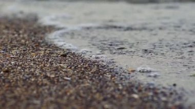 Denizde şeffaf bir dalga. Sahile yakın, deniz altyapısı var.