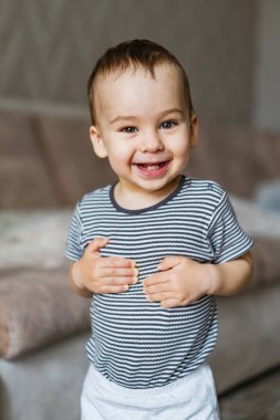Elleri birbirine kenetlenmiş genç bir çocuk. Elleri birarada duran küçük bir çocuk.