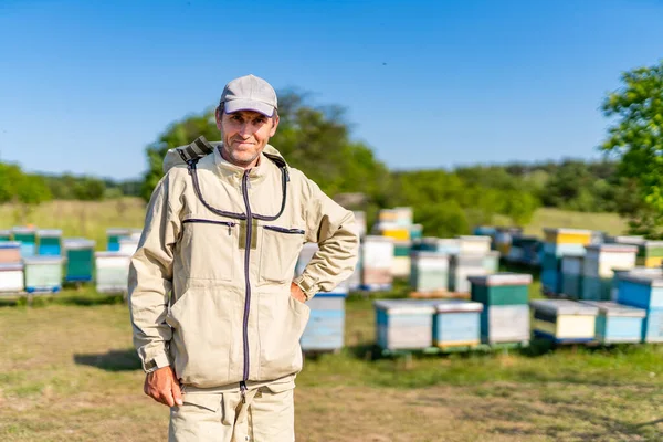Man standing in front of beehives. A man standing in front of a bunch of beehives