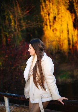 Beyaz önlüklü bir kadın parmaklıklara yaslanıyor.