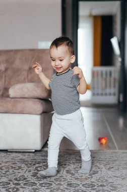 Oturma odasında duran küçük bir çocuk.