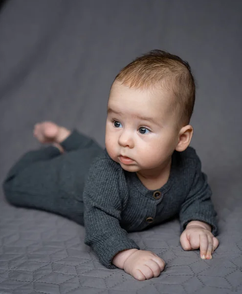 Bebé Acostado Una Cama Con Una Manta Gris — Foto de Stock
