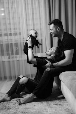 Gülümsüyor, annelik yapıyor. Yeni doğmuş bebeği olan neşeli bir aile..