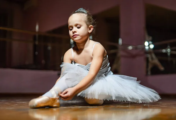 Little Ballerina in Training. A little girl sitting on the floor in a ballet outfit
