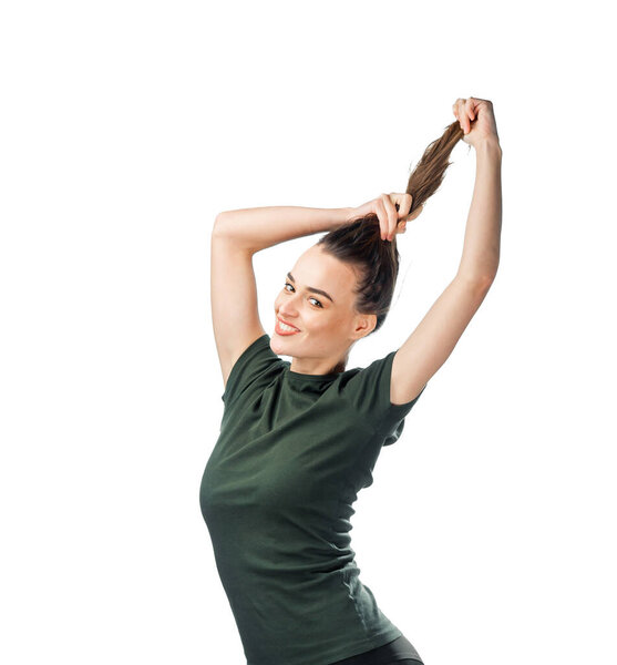 Woman With Green Shirt Holding Hair. A woman in a green shirt is holding her hair
