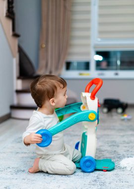 Playful Discovery 'de Neşeli Bebek. Yerde oyuncakla oynayan bir bebek.