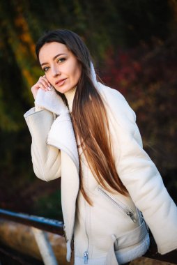 Korkuluğa dayanmış beyaz ceketli bir kadın. Beyaz Ceketli Kadın Demiryoluna Yaslanıyor