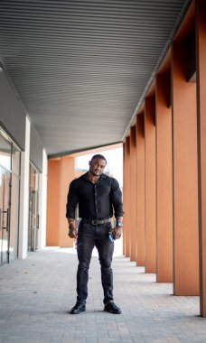 Bir binanın önündeki kaldırımda duran bir adam. Alacakaranlıkta bir şehir manzarasına hayran gezen bir beyefendi.