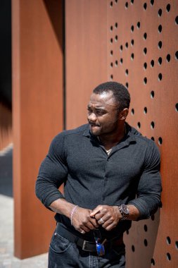 Elleri ceplerinde duvara yaslanmış bir adam. Duvara yaslan, Eller Cepte