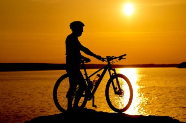 Bir Adam ve Bisikletiyle Serene Beachscape. Sahilde bisikletin yanında duran bir adam.