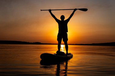 Suda kürek tahtasında duran bir adam. Bir Serene Anı: Kristal berrak suda Kürek Tahtasında Duran Adam