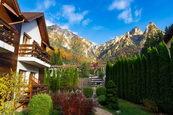 A house with a mountain in the background. A Cozy Mountain Retreat with Majestic Views of Nature