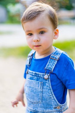 Mavi gömlekli ve tulumlu küçük bir çocuk. Mavi Tulumlu Küçük Çocuğun Tuhaf Maceraları