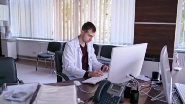 Bilgisayarla çalışan bir doktor. Ofiste bilgisayarla çalışan doktor görüntüsü