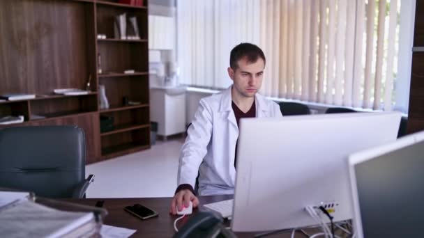 Επαγγελματίας Γιατρός Στο Γραφείο Γιατρός Που Χρησιμοποιεί Τον Υπολογιστή Του — Αρχείο Βίντεο