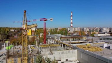 İnşaat alanı yukarıdan vurulmuş. Vinçli inşaat alanı açık havada çalışıyor