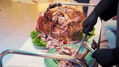 Garson misafirler için tavuk kesiyor. Garson müşteriye bir parça taze kızarmış tavuk verir.