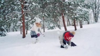 Çocuklar karda dışarıda oynarlar. Mutlu çocuklar eğleniyor, kış yürüyüşünde dışarıda oynuyorlar.