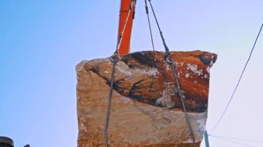 Taş ocağında mermer bloklar ve vinç. İnşaat alanı için vinç makinesi ve ekipman