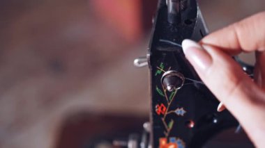 İğneye iplik takan kadına yaklaş.