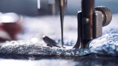 Dikiş makinası ayağıyla iğne yapıyor.