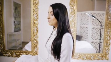 Kozmetik masasında uzanmış güzel bir genç kadının portresi.