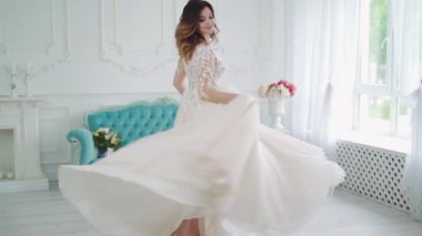 Işık odasında güzel bir gelin. Gelin içeride, beyaz stüdyo içinde tıpkı evdeki gibi güzel elbiseler içinde.