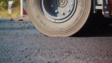 Asfalt yayıcı yerinde çalışıyor. İnşaat halindeki yoldaki asfalt manzarasını kapat