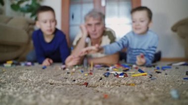 İnşaat oyuncağıyla oynayan çocuklar. Dedenle lego oynayan çocukların manzarası.