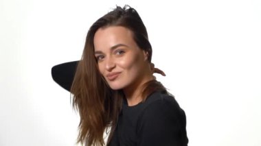 Stüdyoda güzel bir genç kadın var. Beyaz arka planda izole edilmiş güzel gülümseyen kadın portresi