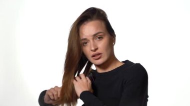 Her kadın için günlük rutin. Saçlarını tarayan, kameraya bakan ve konuşan güzel bir genç kadının portresi.