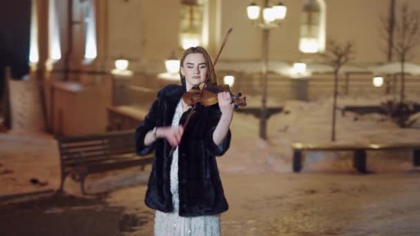 街头小提琴家女孩 年轻优雅的女小提琴手晚上在街上拉小提琴 — 图库视频影像