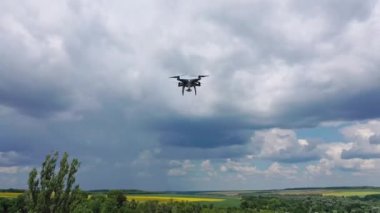 Tarlaların üzerinde İHA uçurmak. Drone mavi gökyüzüne karşı kamera kullanarak havadan çekim yapıyor.
