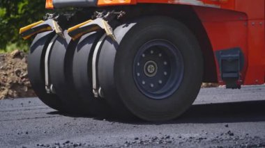 Taze asfalt yapısı. Yeni yol inşaatında çalışan yol silindirinin yakın görüntüsü