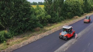 Asfalt silindirlerin havadan görünüşü. Yol yapımı paten sıkıştırma makinesiyle çalışıyor